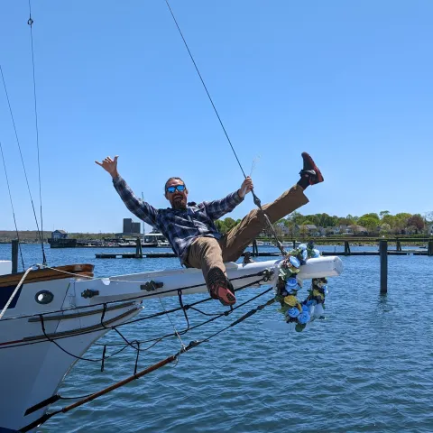 a group of men riding on the back of a boat in the water
