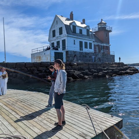 a group of people standing on a dock near the water